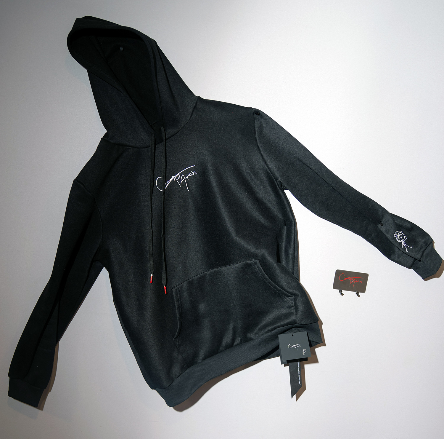 Black hoodie with white logo and tags.