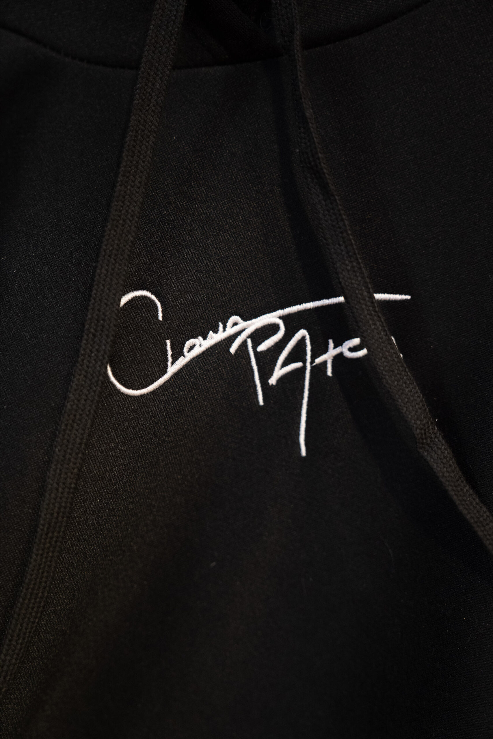 Black hoodie with white embroidered signature logo.